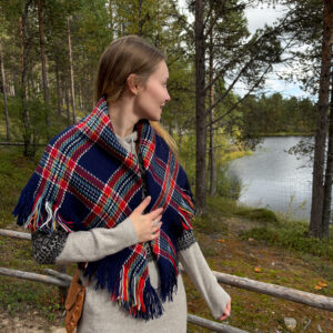 Sininen villahuivi henkilön harteilla järvimaisema taustalla