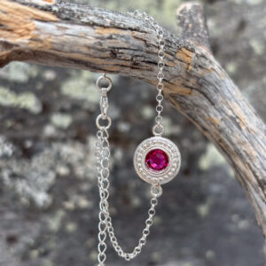 pinkillä korukivellä koristeltu rannekoru