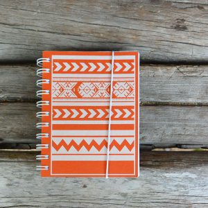 Oranssi valkoinen muistikirja Essi Ranttilan suunnittelemalla tiuhta-kuviolla