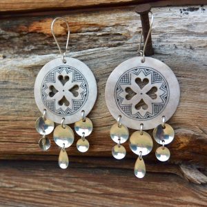 Ilmari Tapiolan poronluusta tehdyt koristeelliset pyöreät korvakorut, joissa sydän kuvio ja joista roikkuu hopeisia laukkasia