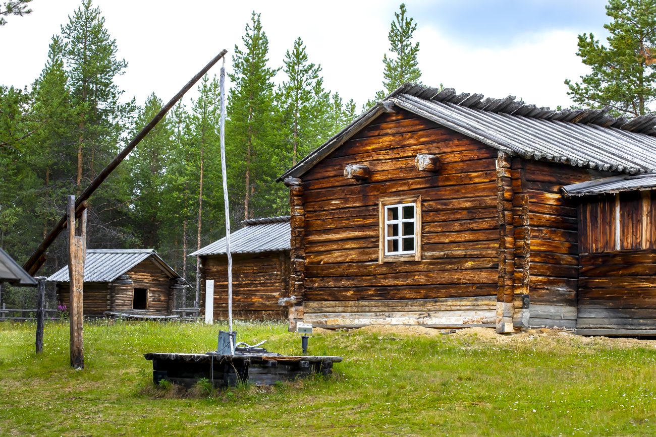 Hirsinen asuinrakennus Tirron tupa, kaksi hirsistä aittaa sekä vanha kaivo.