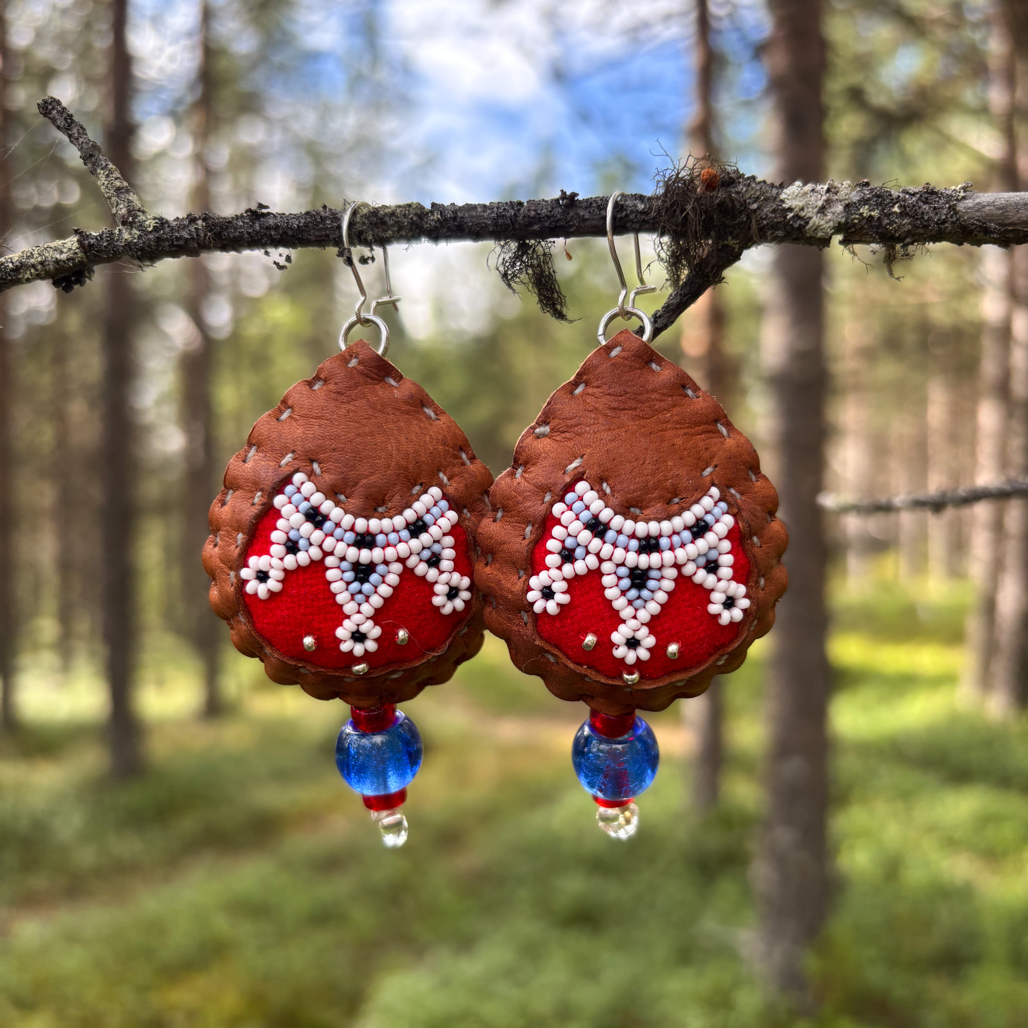 Heini Wesslinin tekemät poronnahkaiset korvakorut, joissa värikkäät käsinkirjaillut helmet.