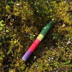 liukuvärjätty kruunukynttilä. Kynttilässä violettia, punaista, keltaista ja vihreää